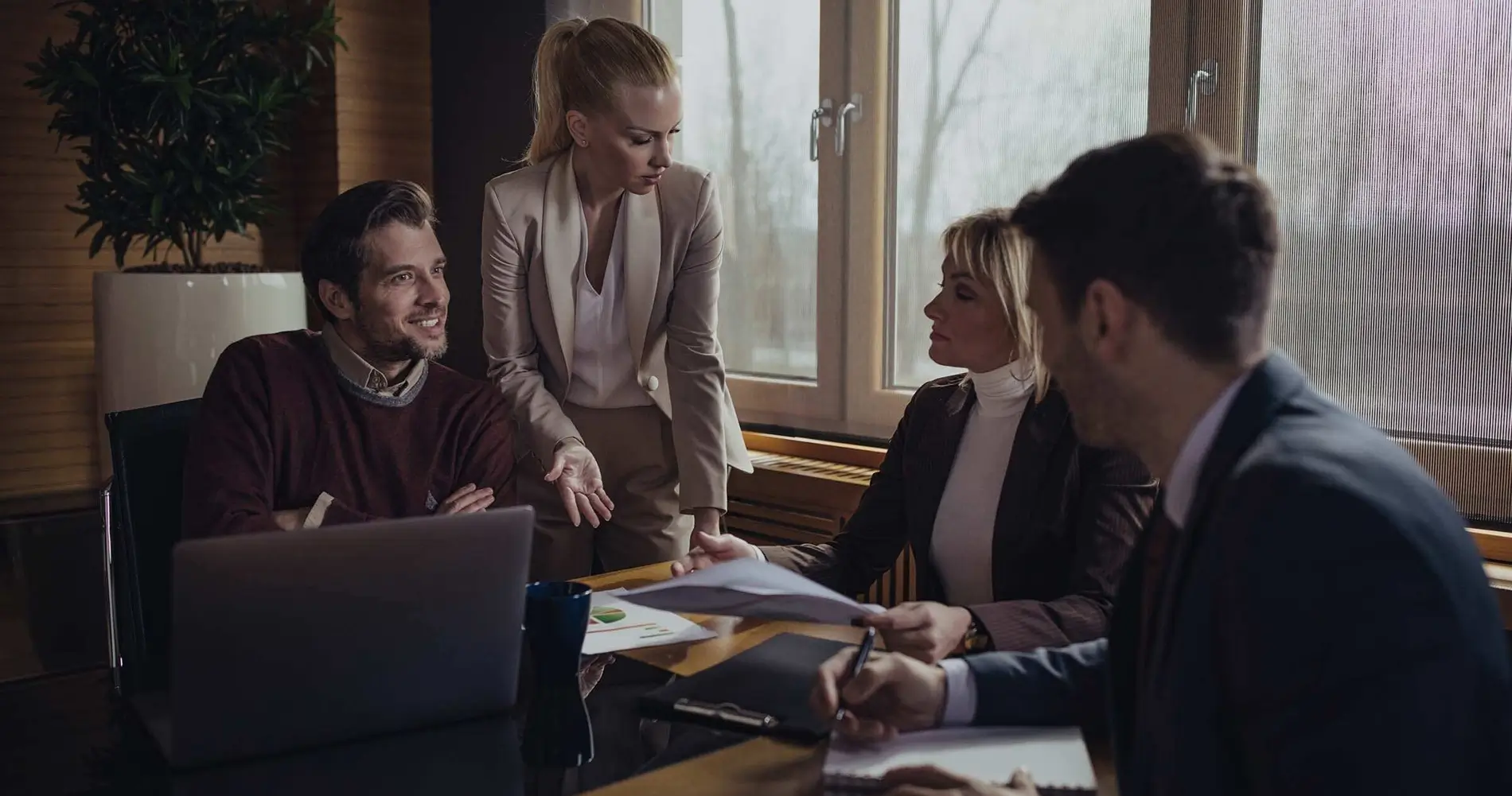 Equipe de Advogados criminalistas em escritório analisando documentos, com uma balança da justiça em primeiro plano.