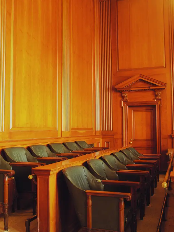 Plenário do Tribunal do Júri vazio, com as cadeiras dos jurados e a mesa do juiz, preparado para um julgamento.